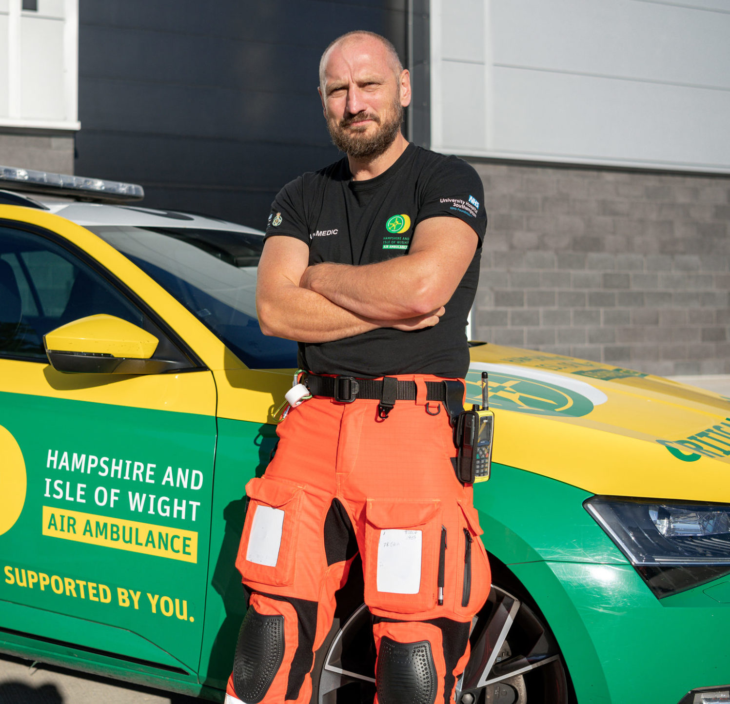 HEMS Paramedic Nick Gray is leaning on the bonnet of the Emergency Response Vehicle